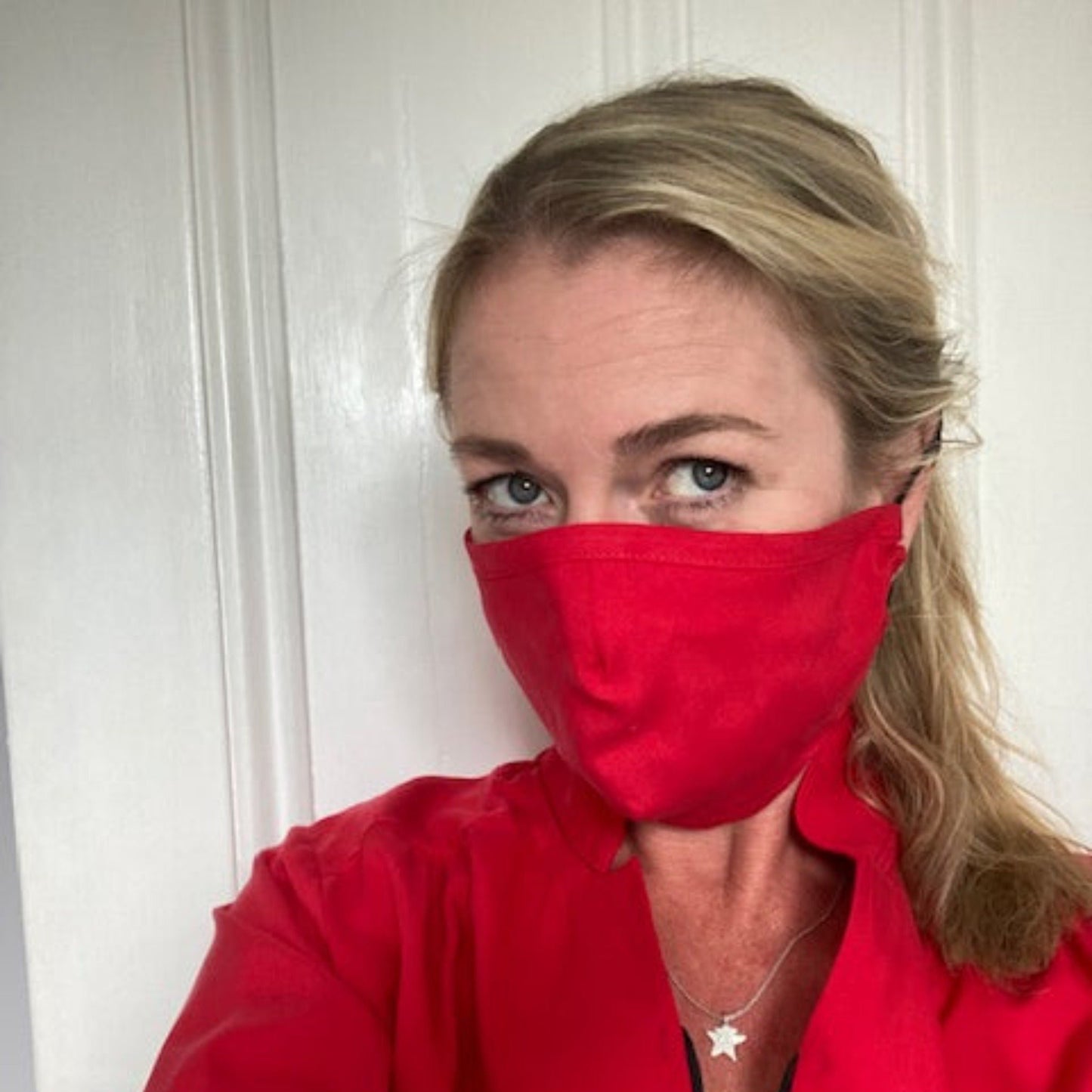 Mozzie Cozzie face mask - filter fitting design for proper face protection and coverage of mouth and nose, secured with metal nose strip for snug fit. Shown here in SquidGame Bright Red by Anna, our founder.